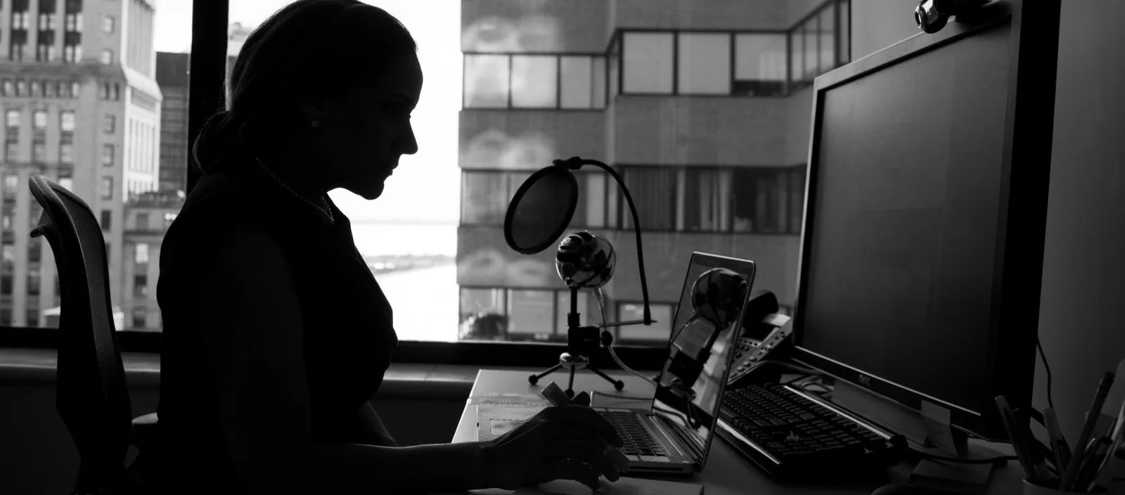 Consultant working at a desk with a microphone and laptop